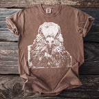 Brown Comfort Colors t-shirt with white graphic of a pigeon's face, size tag visible.