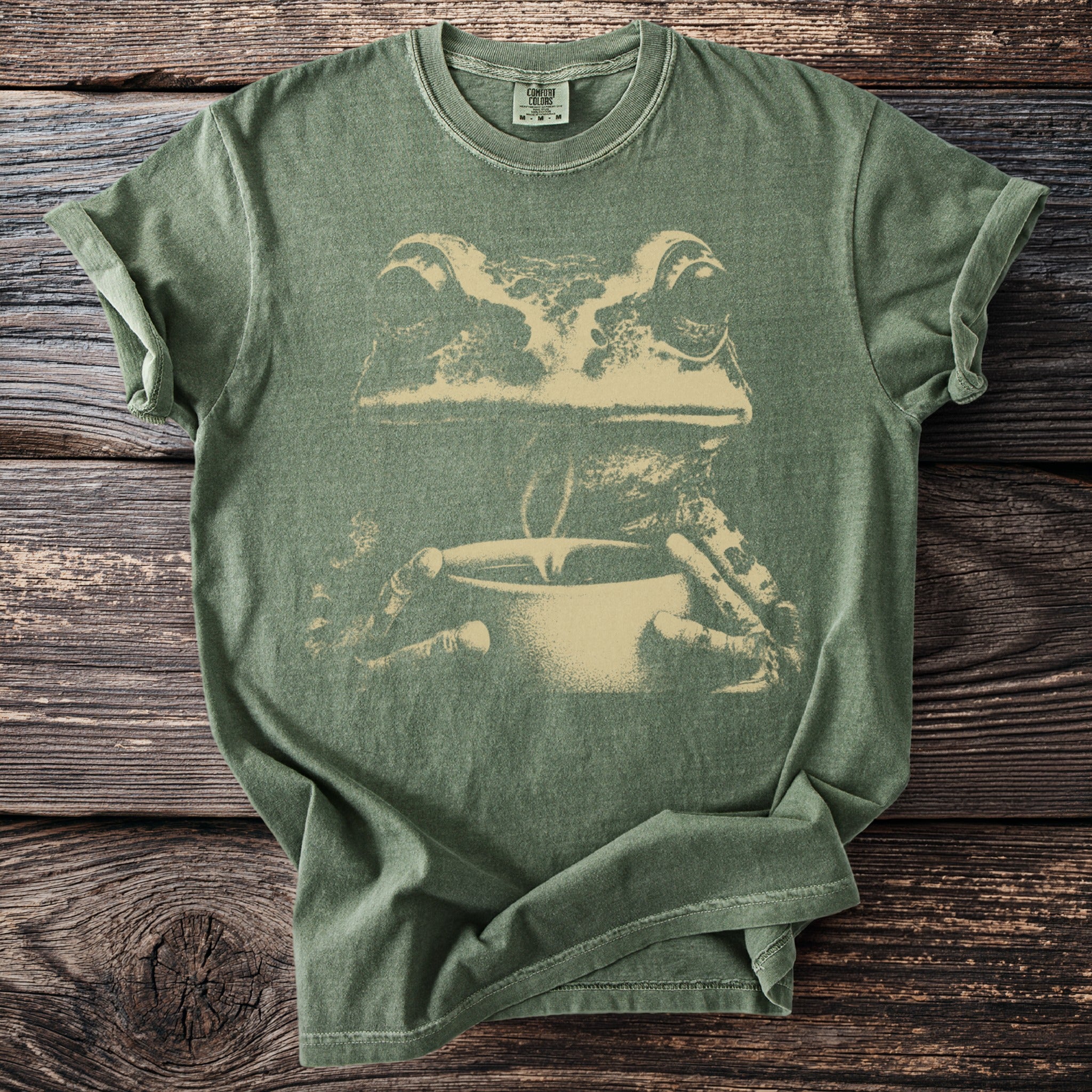 Green t-shirt with a distressed graphic of a frog holding a coffee cup.