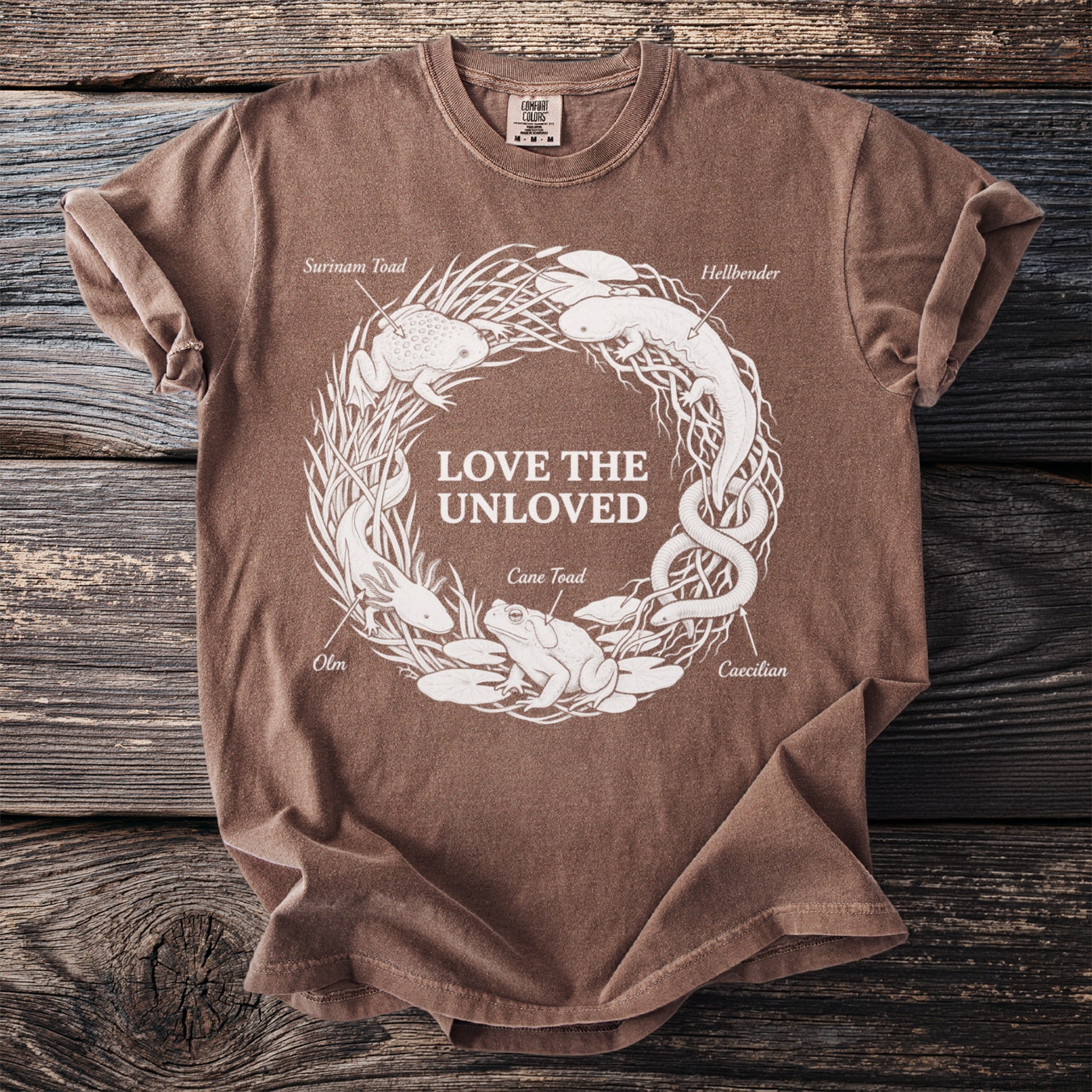 Brown t-shirt with white circular graphic of amphibians and text "LOVE THE UNLOVED".