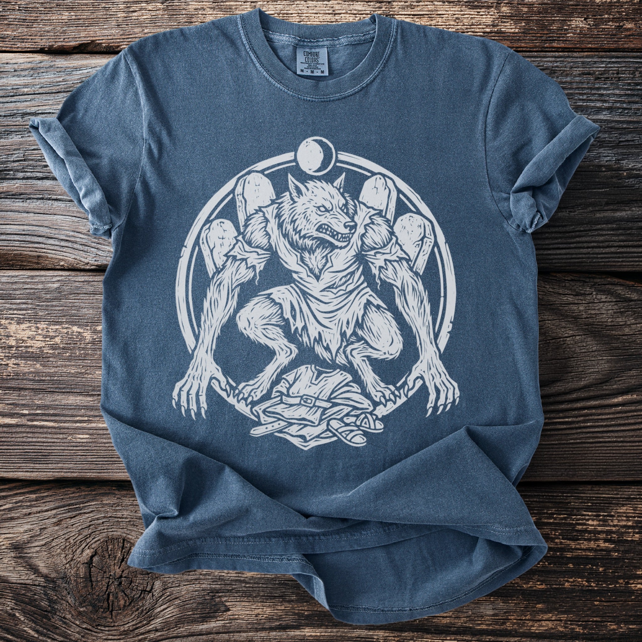Blue t-shirt with white werewolf and moon graphic and Comfort Colors tag.