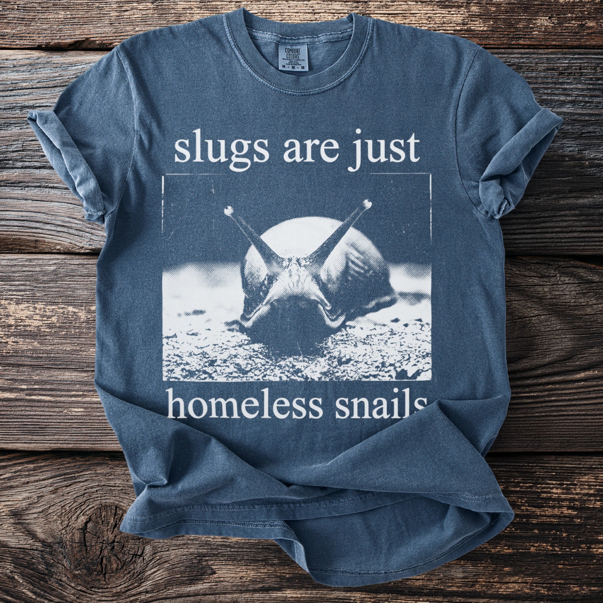 Blue t-shirt with text "slugs are just homeless snails" and a snail graphic.
