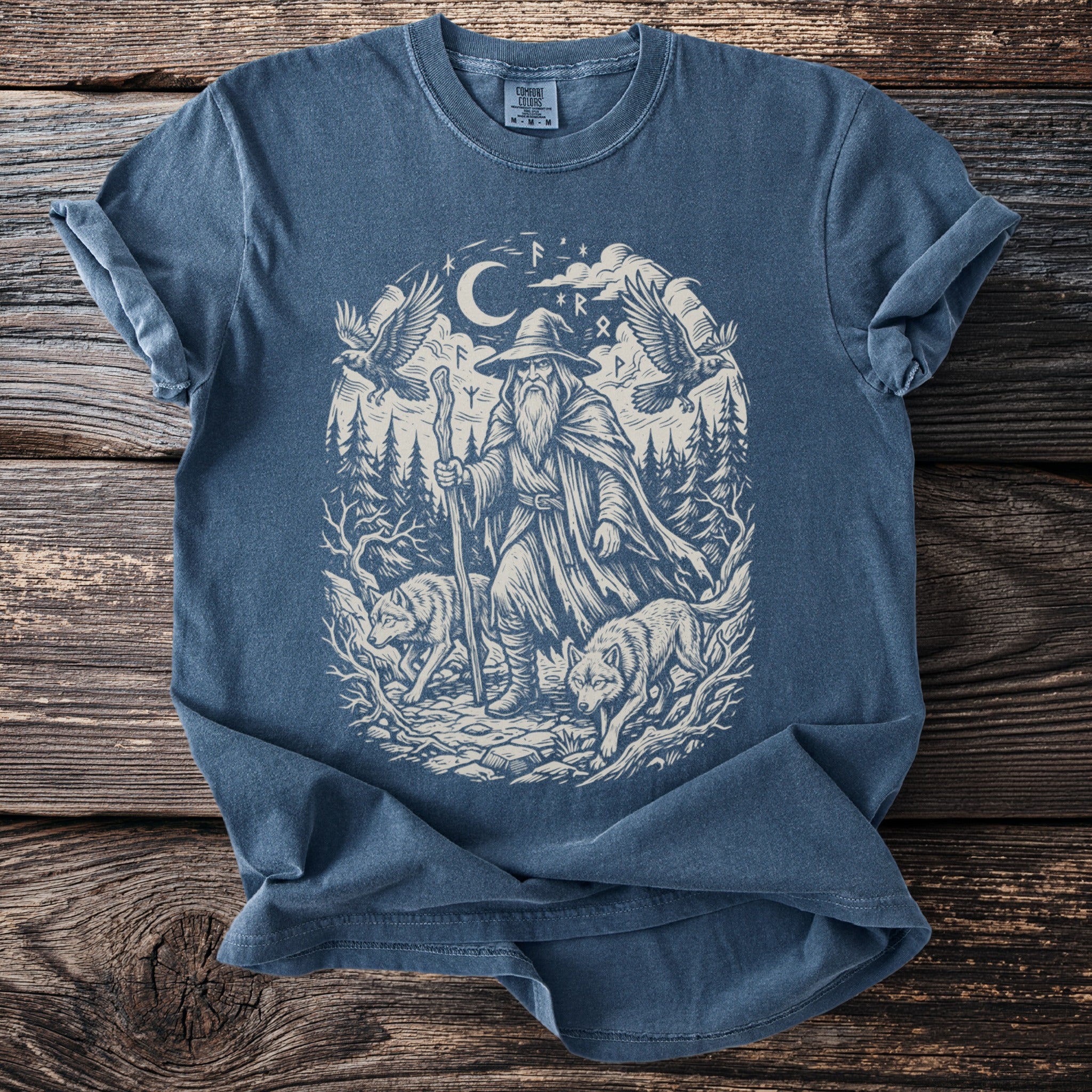 Blue t-shirt with a mystical wizard, wolves, eagles, and rune stones graphic.