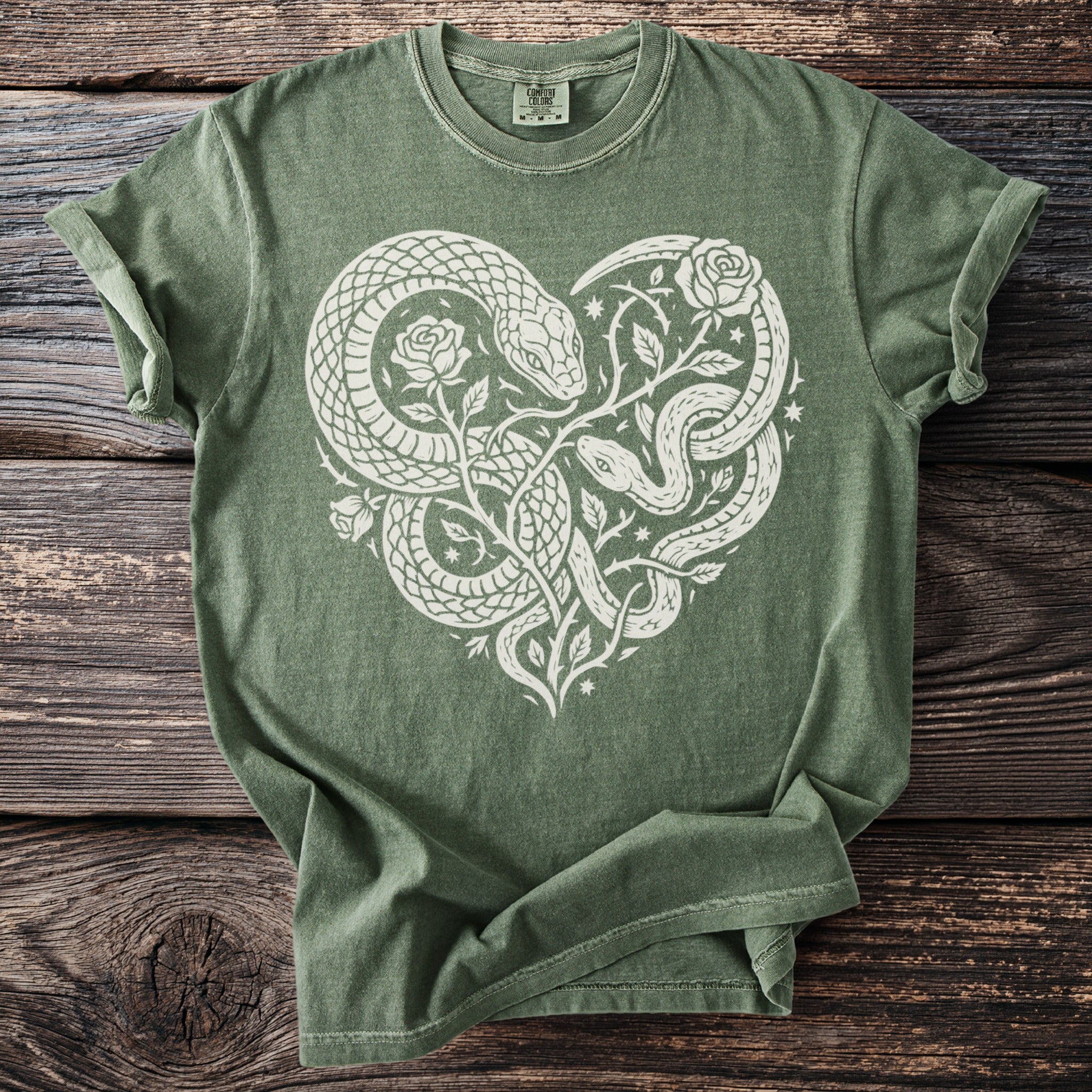 Olive green t-shirt with white snakes and roses forming a heart shape.