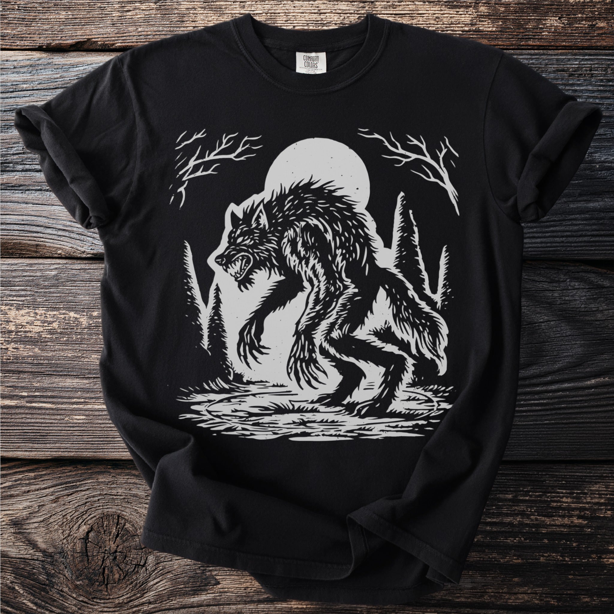 Werewolf illustration on black t-shirt with moon and trees.