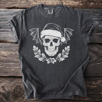 Dark t-shirt with white skull wearing Santa hat, bat wings, and holly wreath.