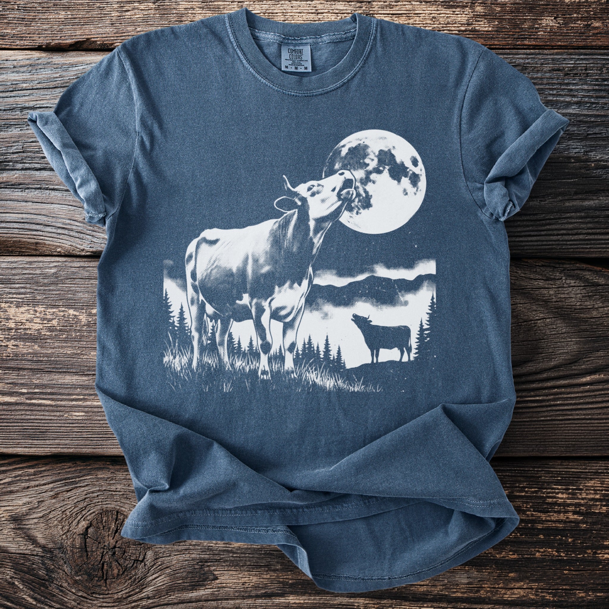 Cow howling at the moon with a smaller cow silhouette in field.