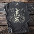 T-shirt with a graphic of robed figures holding torches around a bonfire with a straw figure.