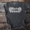 Dark grey t-shirt with white "Merry Gothmas" text and skull graphic.