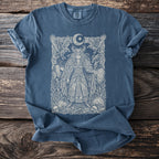 Blue t-shirt with intricate white print of a warrior queen with ravens and moon.