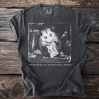 T-shirt with opossum eating from trash and text "everything is technically edible".