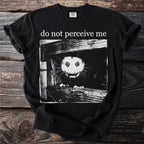 Black T shirt with a bushbaby peering through wooden planks and “do not perceive me” text.
