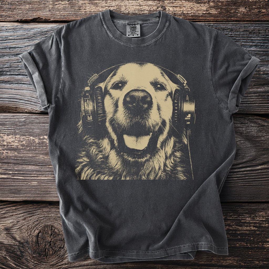 Dark grey t-shirt with gold print of a smiling dog wearing headphones on a wooden background.