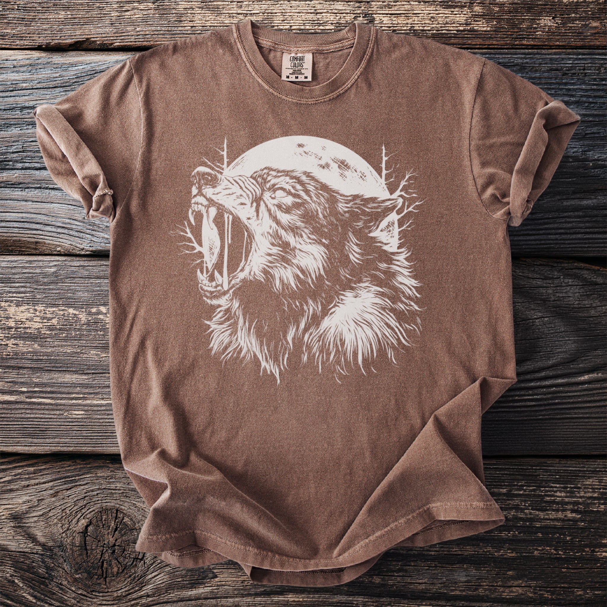 Brown t-shirt with white wolf howling at the moon graphic.