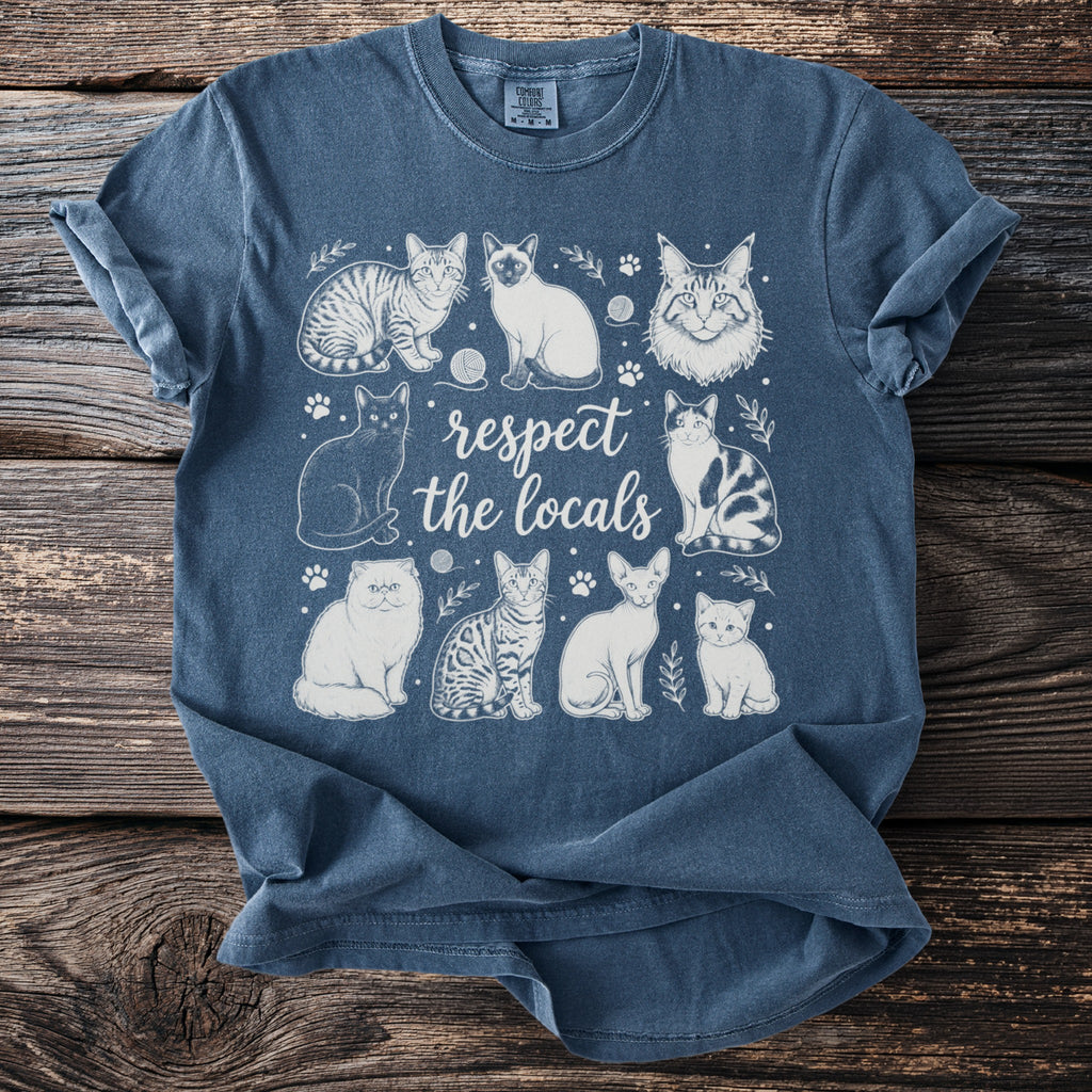 Blue t-shirt with "respect the locals" and various sketched cats.