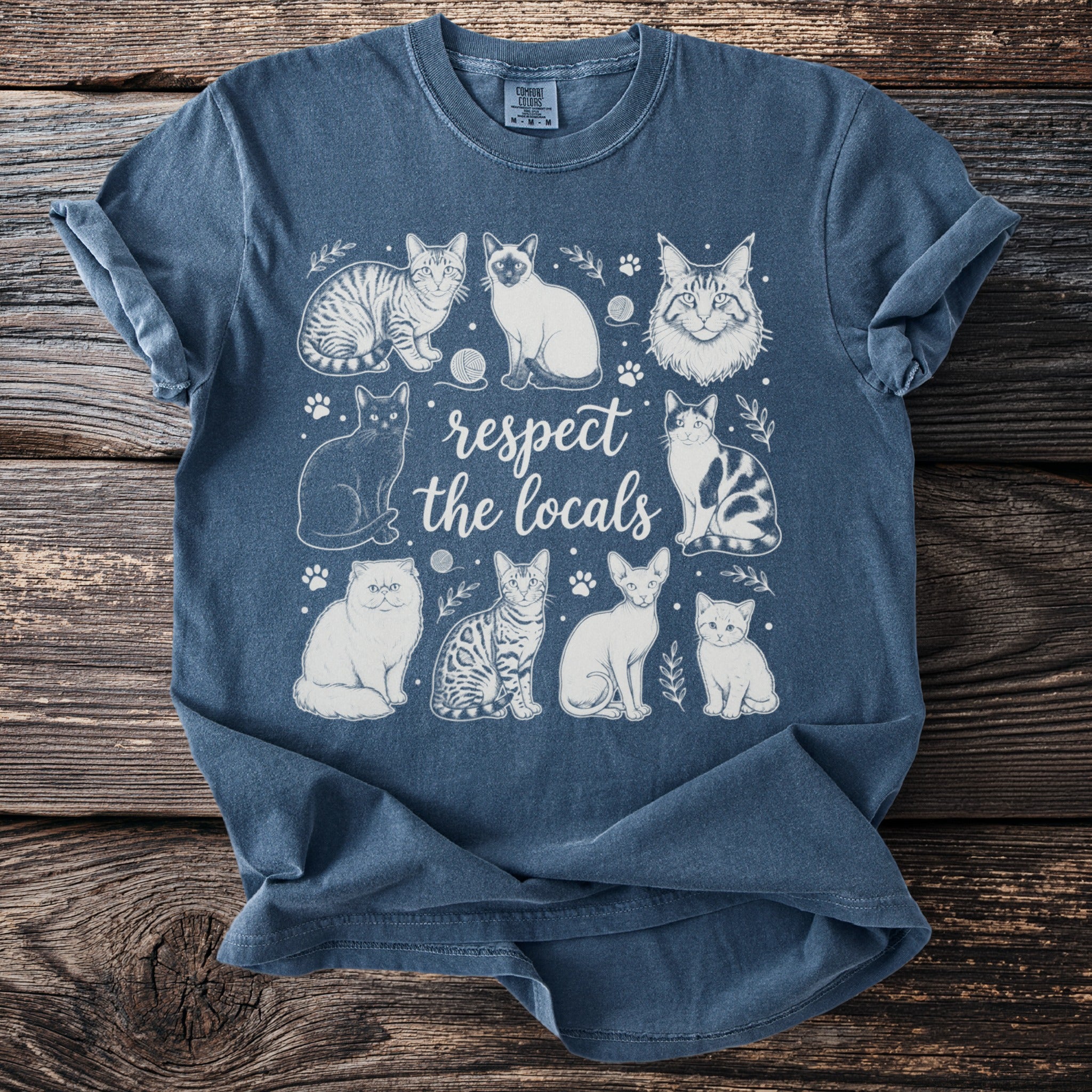 Blue t-shirt with "respect the locals" and various sketched cats.