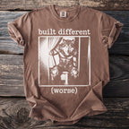 Brown t-shirt with white graphic of a wolf in jeans saying "built different (worse)".