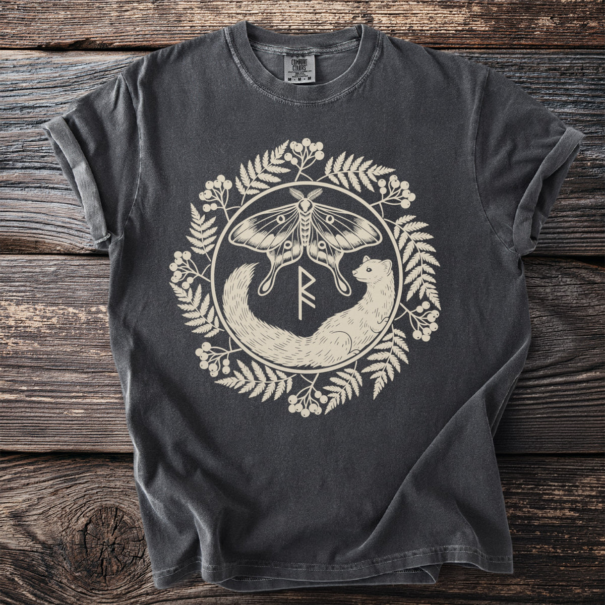 Pepper t-shirt with a luna moth and stoat flanking a rune inside a berry wreath.