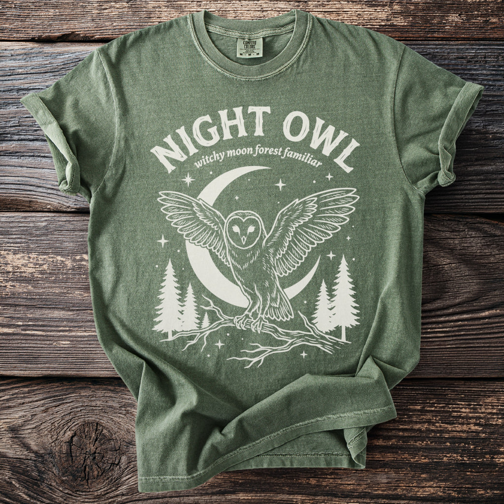 Green t-shirt with white graphic of an owl, moon, and trees. Text reads "NIGHT OWL"
