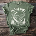 Green t-shirt with white graphic of an owl, moon, and trees. Text reads "NIGHT OWL"