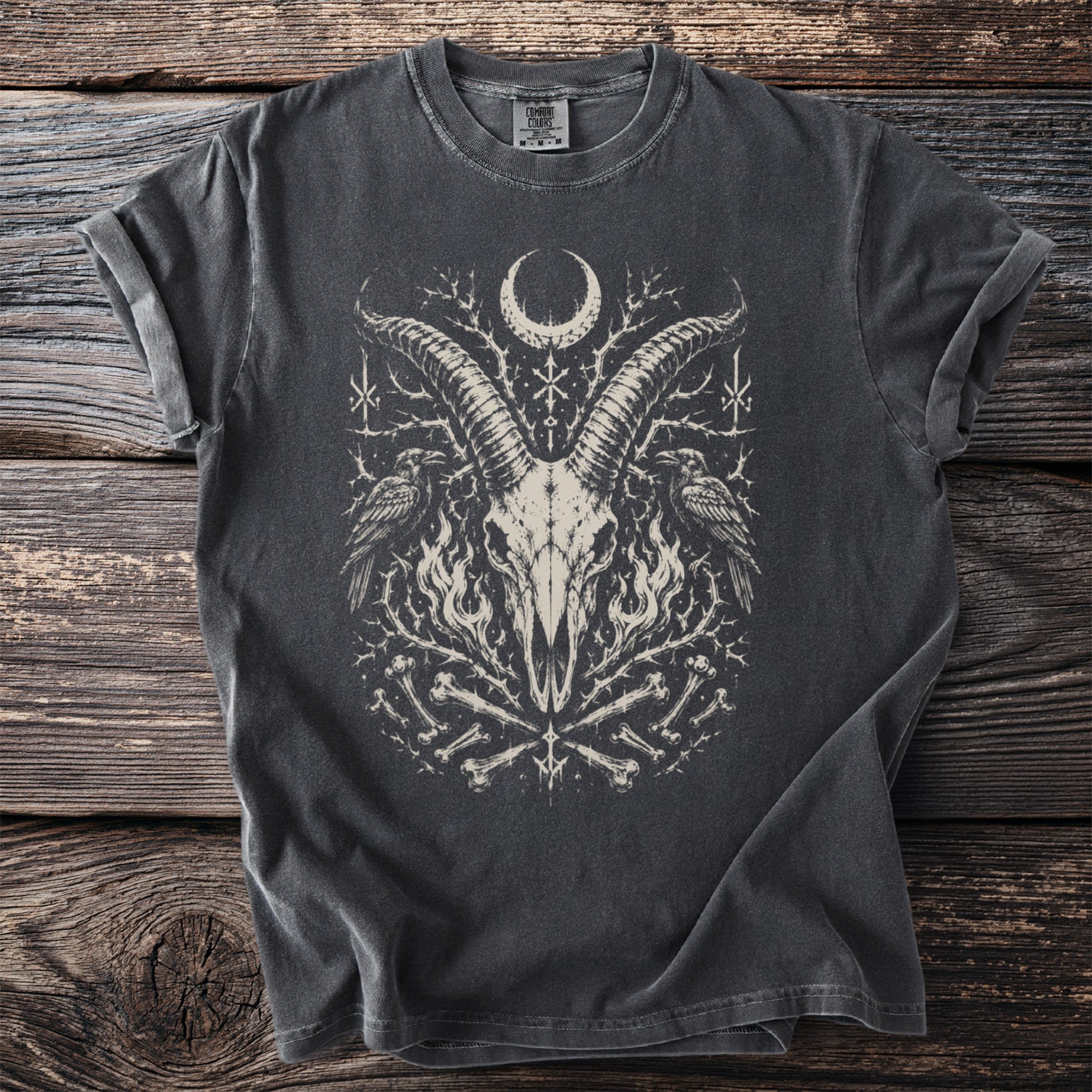 Dark t-shirt with a gothic graphic of a goat skull, ravens, moon, and bones.
