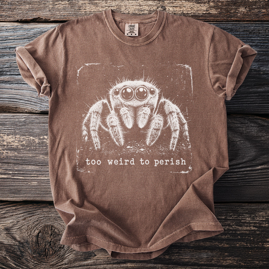 Brown t-shirt with a white graphic of a jumping spider and the text "too weird to perish".