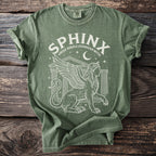 Green t-shirt with a white graphic of a winged sphinx and the text "SPHINX GREEK RIDDLE GUARDIAN MYTH".