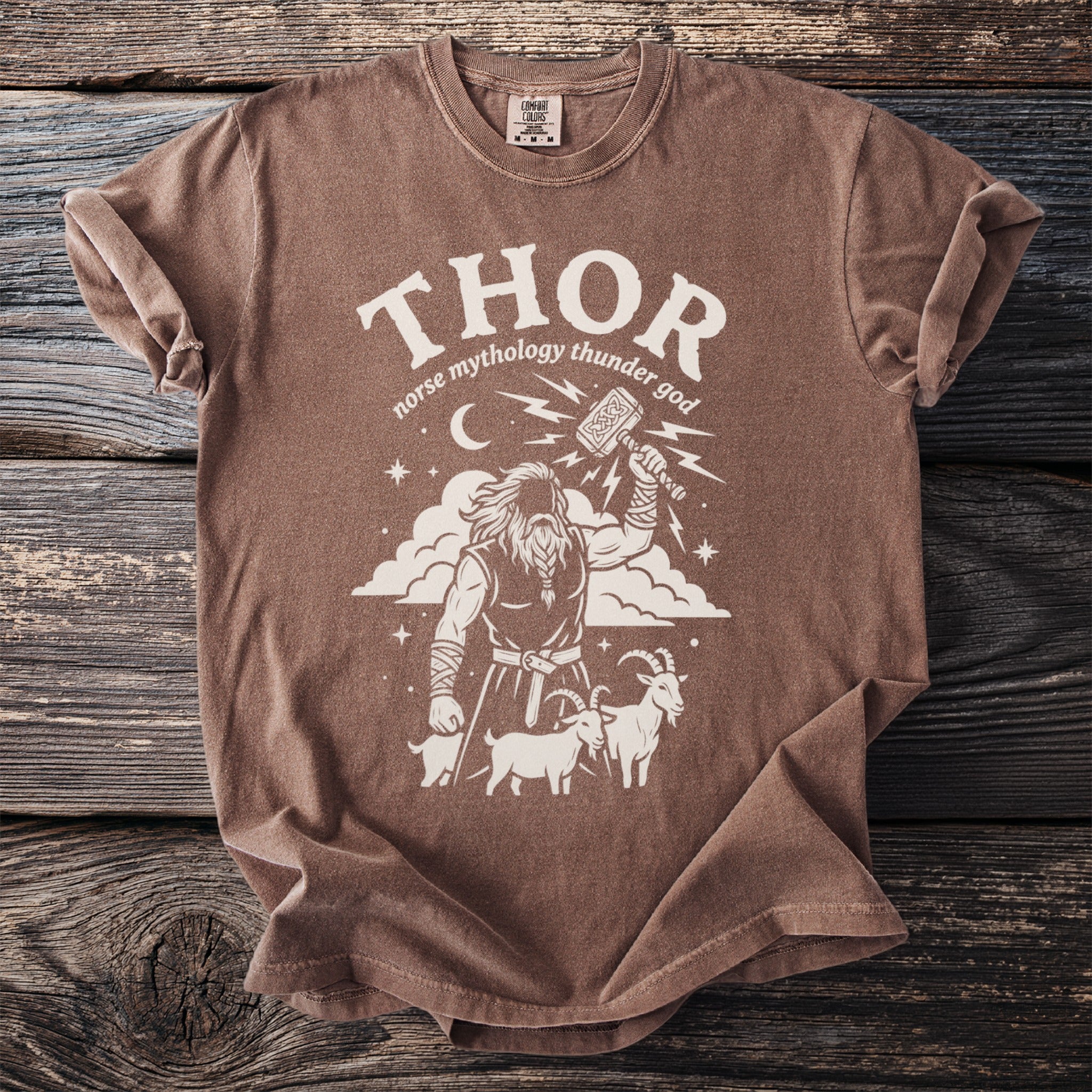 Brown t-shirt with white graphic of Thor raising Mjolnir, flanked by goats and clouds.