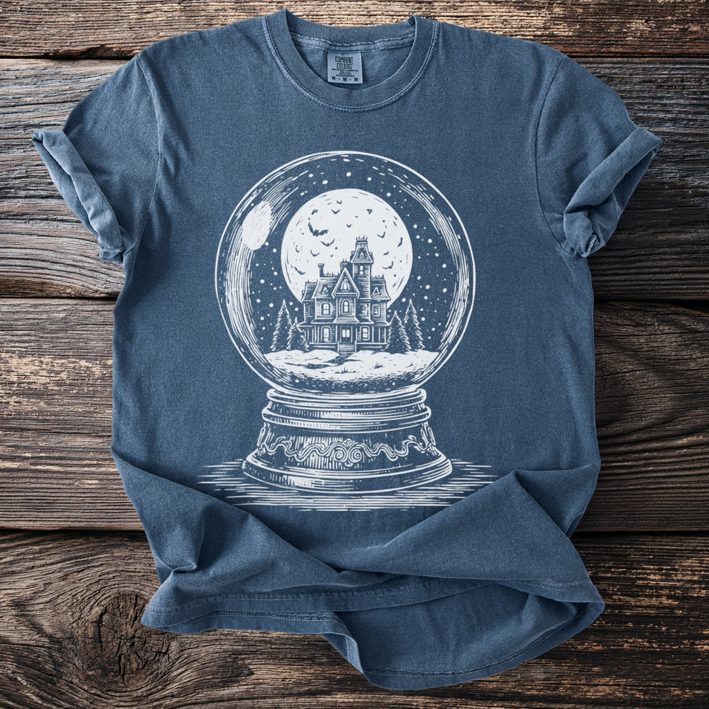 Blue t-shirt with a white graphic of a haunted house inside a snow globe.