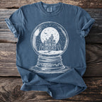 Blue t-shirt with a white graphic of a haunted house inside a snow globe.