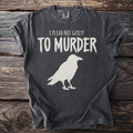 Charcoal t-shirt with white text "I plead not guilty to murder" and a raven graphic.