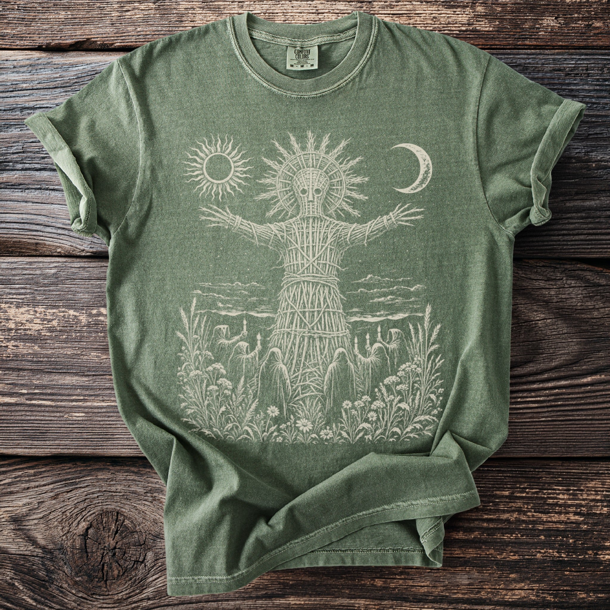 Green t-shirt with wicker man, sun, moon and robed figures graphic.