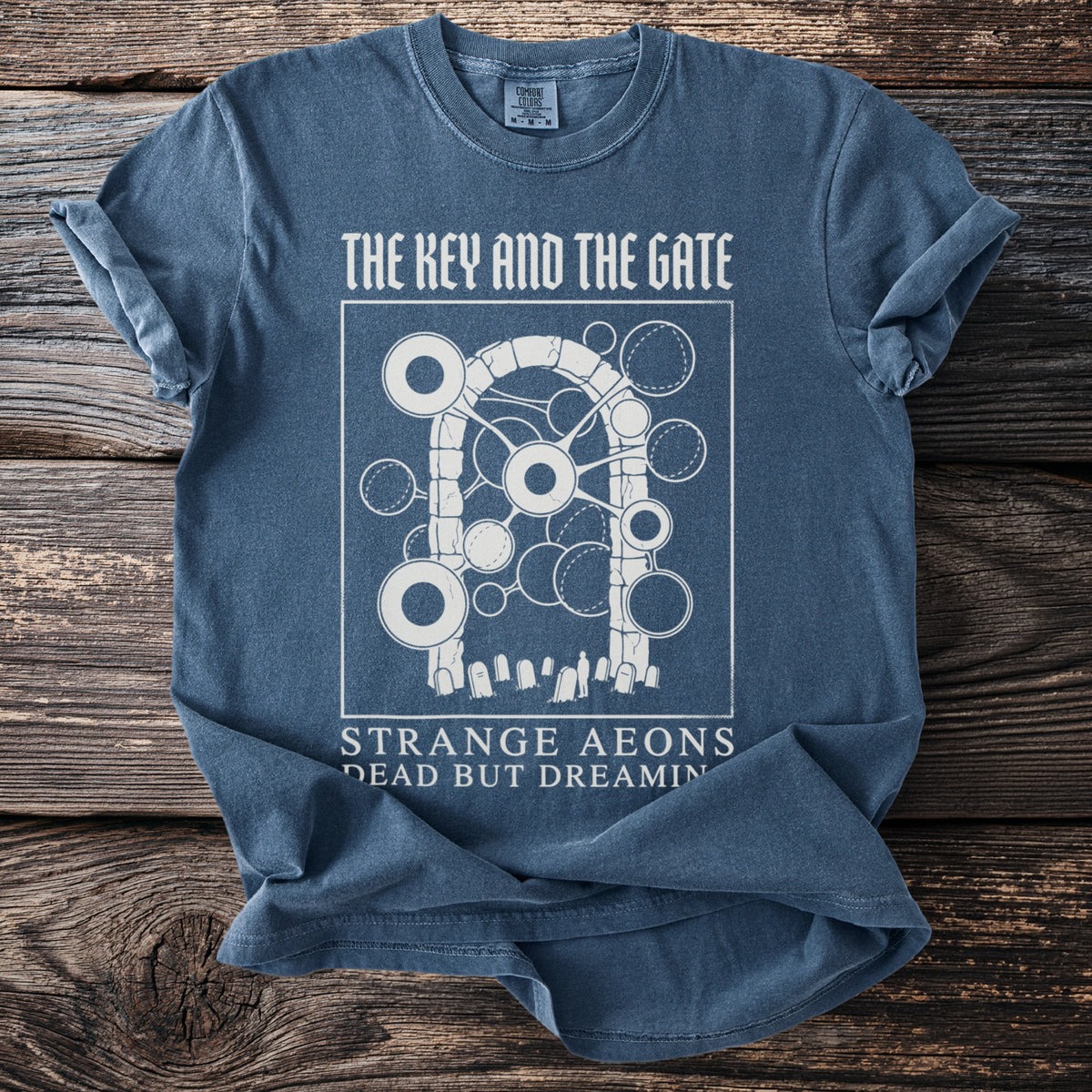 Blue t-shirt with white graphic "The Key and the Gate" and "Strange Aeons Dead But Dreamin".