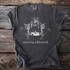 Dark t-shirt with three cats sitting around a table with a candle. "meeting adjourned" text.