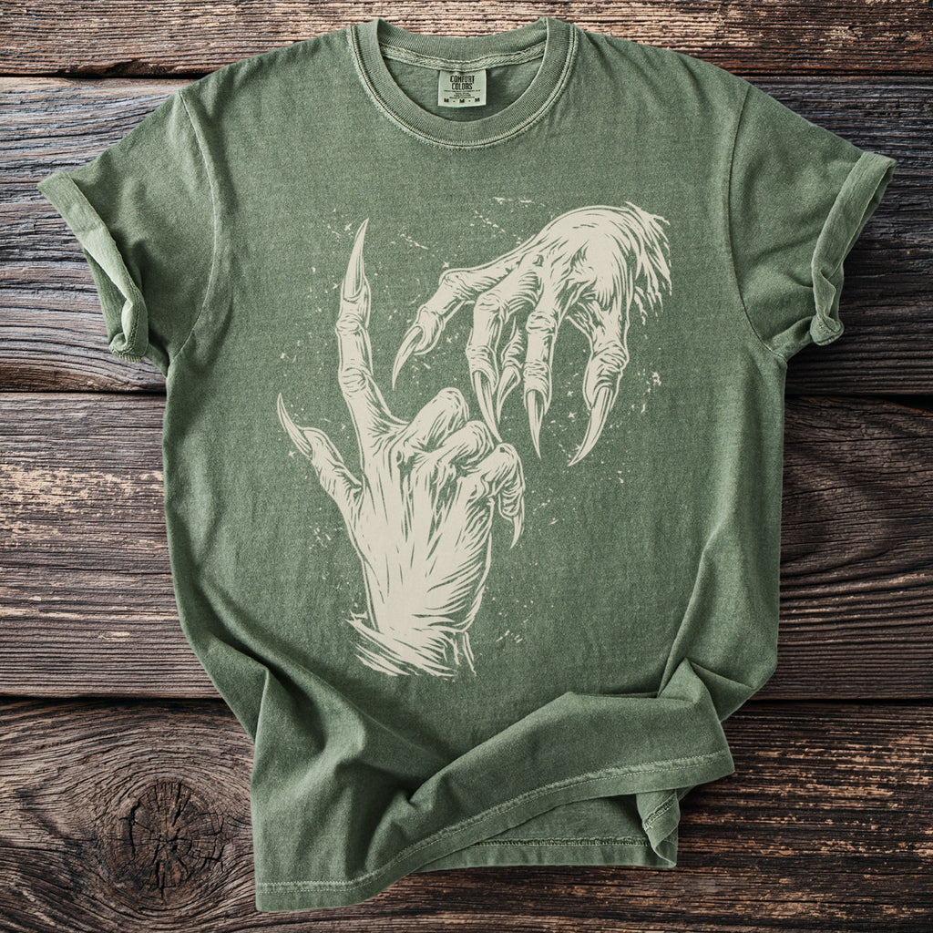 Green t-shirt with an off-white graphic of two spooky, clawed hands on a wooden background.