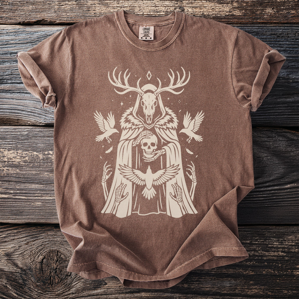 Brown t-shirt with a skull, skeleton hands, antlers, and birds graphic.