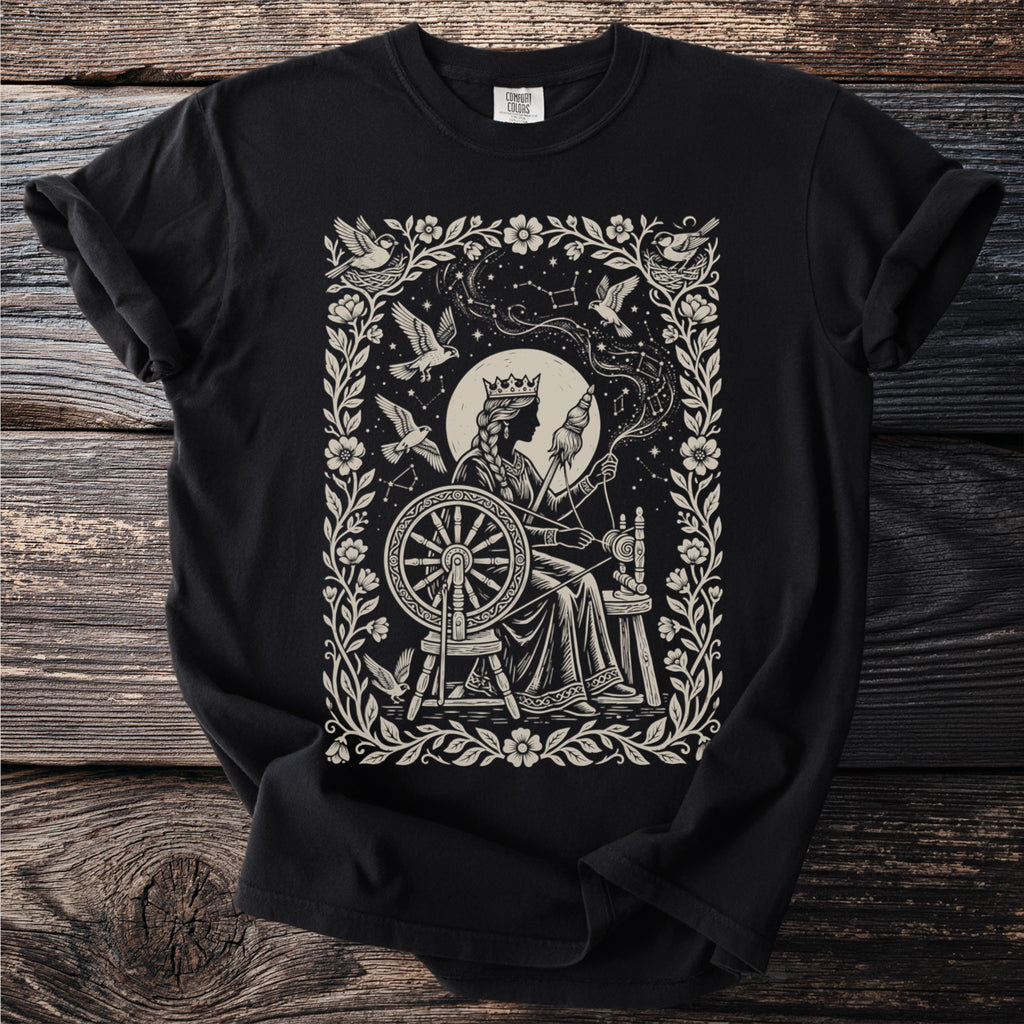 Black t-shirt with a queen at a spinning wheel surrounded by birds and constellations.
