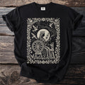 Black t-shirt with a queen at a spinning wheel surrounded by birds and constellations.