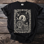 Black t-shirt with a queen at a spinning wheel surrounded by birds and constellations.