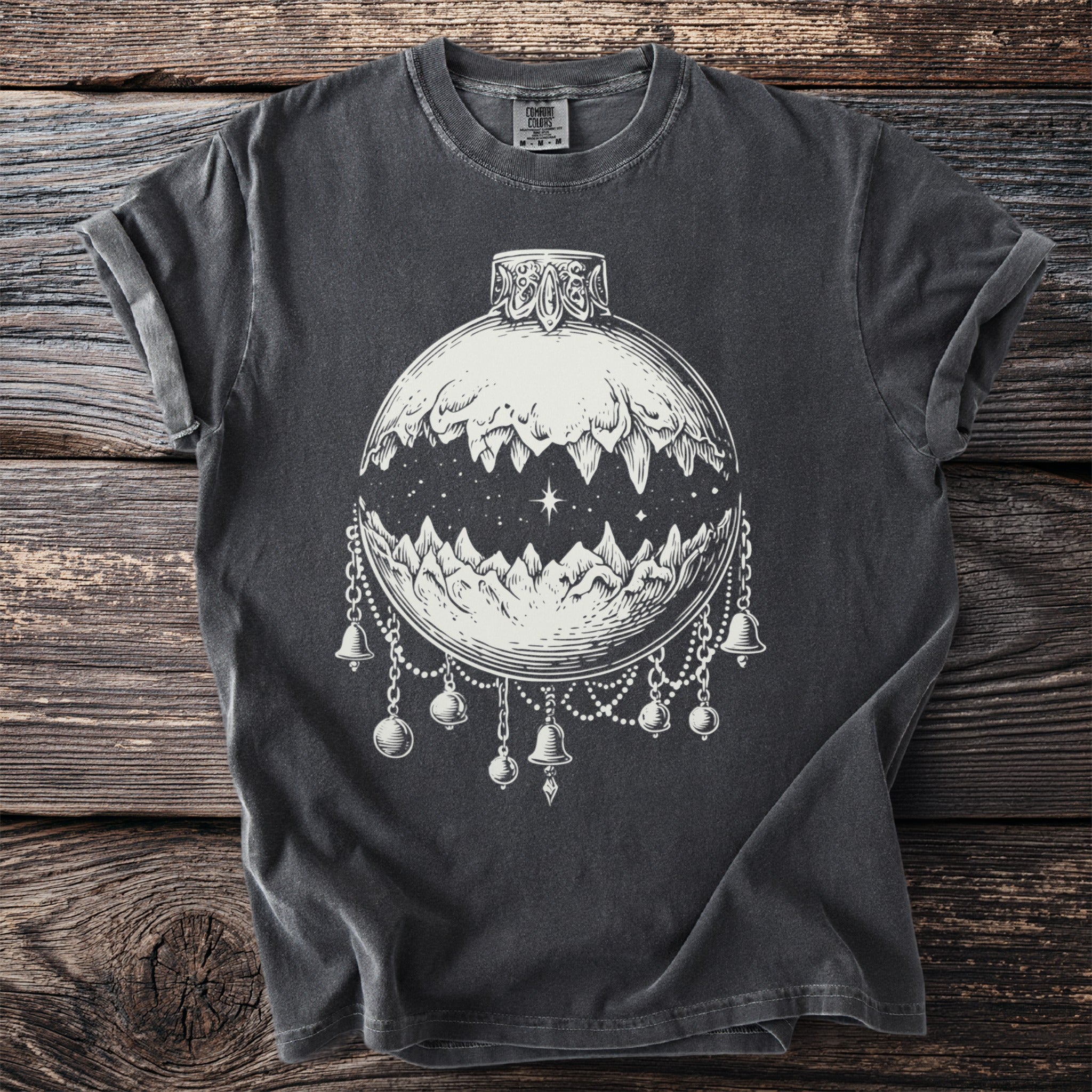 Dark grey t-shirt with white graphic of a moon phase ornament with mountains and bells.