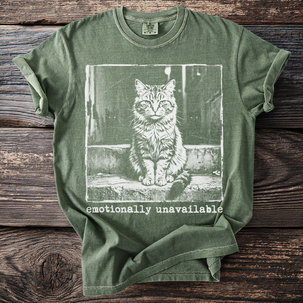 Green t-shirt with a graphic of a cat sitting on steps and the words "emotionally unavailable".