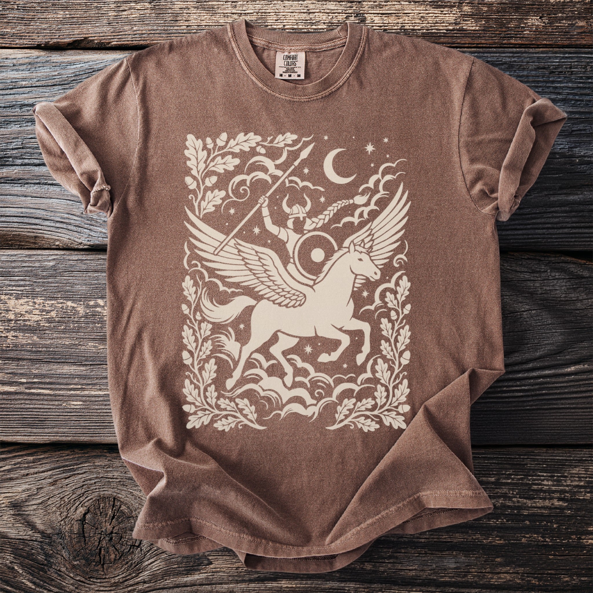Brown t-shirt with winged horse and warrior graphic, moon, and oak leaves.