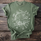 Green t-shirt with white line art of Krampus wrapped in chains and bells.