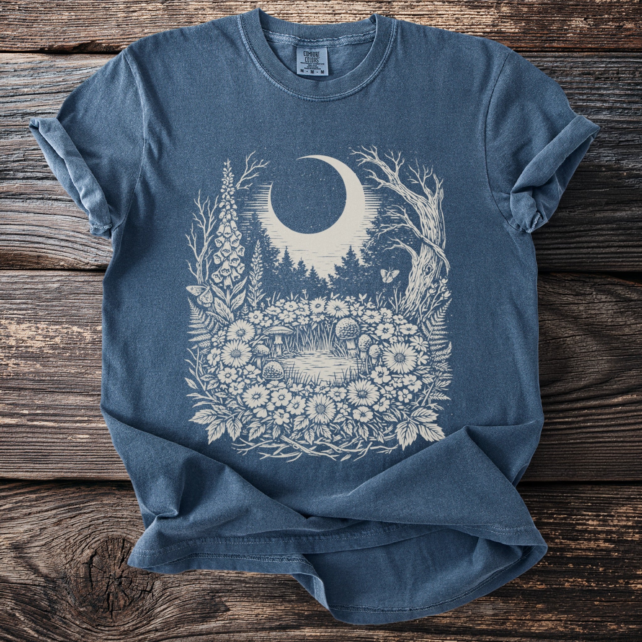 Blue t-shirt with a cream vintage woodland scene featuring a moon and forest.