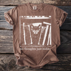Brown t-shirt with white graphic of kitten hiding among books and text "no thoughts just hiding".
