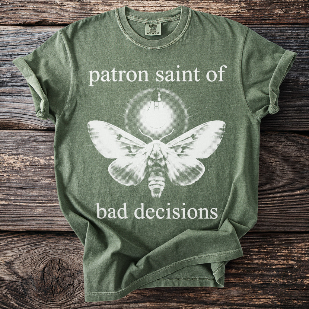 Green t-shirt with moth, lightbulb, and text "patron saint of bad decisions".