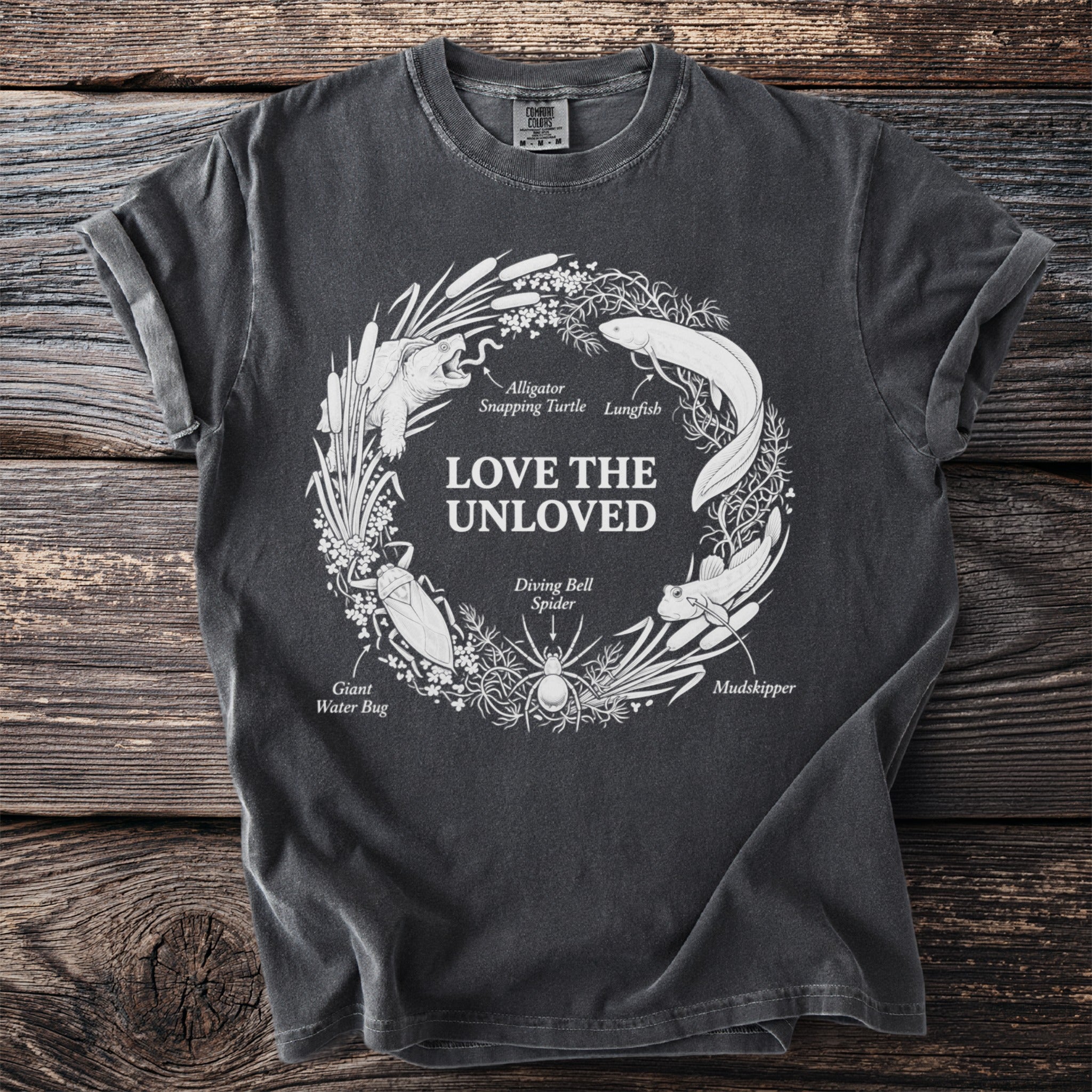 Dark grey t-shirt with "Love the Unloved" and illustration of unloved creatures.