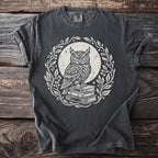 Dark gray t-shirt with white linocut print of owl on books within floral wreath.
