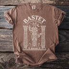 Brown t-shirt with line art of Bastet, Egyptian cat goddess, holding ankh.