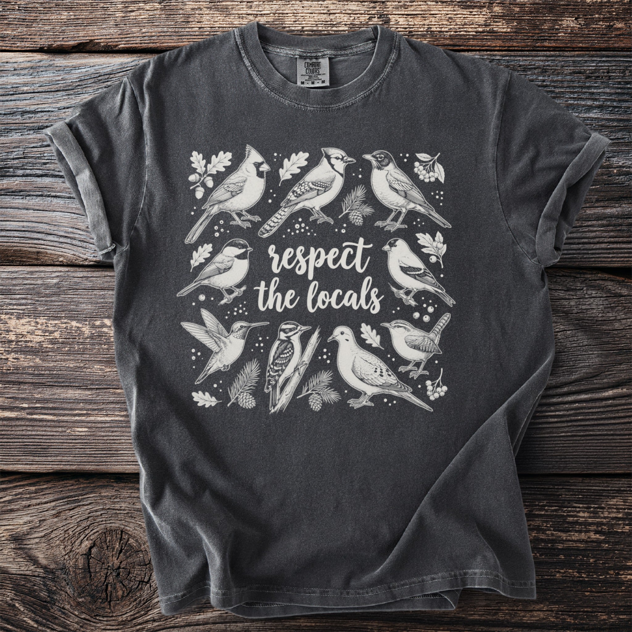 Dark grey t-shirt with white illustration of various birds and text respecting the locals.