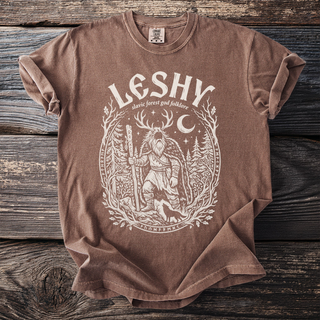 Brown t-shirt with "LESHY slavic forest god folklore" text and woodland graphic.